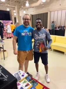 Dillon standing with a fan at Forever Con '23 showcasing some comics he purchased